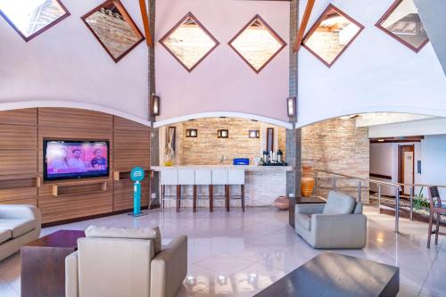 a living room with a tv and a table at Best Western Shalimar Praia Hotel in Porto Seguro