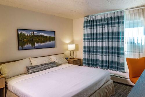a bedroom with a bed and a large window at Bridgewater Hotel, Trademark Collection by Wyndham in Fairbanks