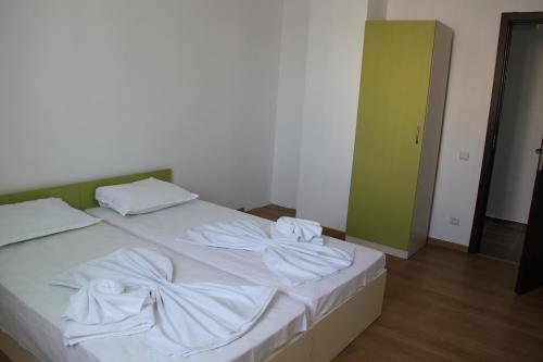 a bed with white sheets and towels on it at Guest House ASK in Primorsko