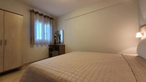 a bedroom with a bed and a window at Vasiliki House in Sarti