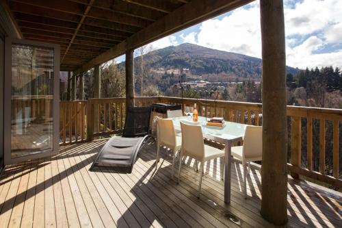 a patio with a table and chairs on a deck at The Love Spa in Queenstown