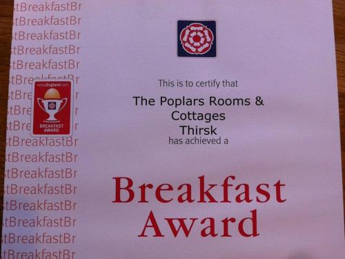 un cartello con i benefici di un premio per la colazione di The Poplars Rooms & Cottages a Thirsk