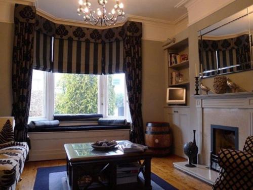 sala de estar con chimenea y ventana en The Poplars Rooms & Cottages, en Thirsk