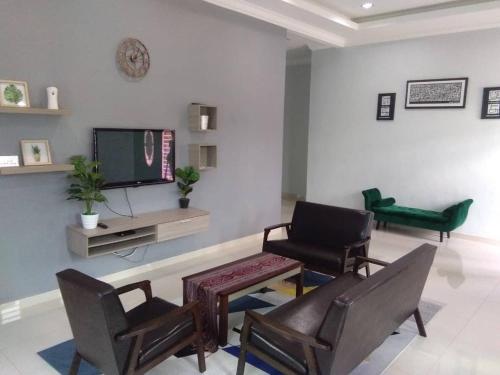 - un salon avec deux chaises et une télévision dans l'établissement Cassa Villa Guest House Pasir Mas, à Pasir Mas