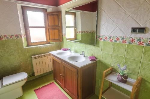 a bathroom with a sink and a toilet and a mirror at La Casa de Bustantegua in Selaya