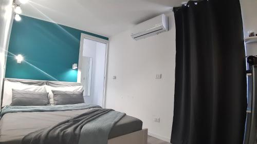 a bedroom with a bed with a blue wall at Panoramic Terrace Room in Giardini Naxos