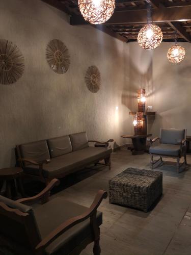a living room with a couch and chairs and lights at Zuri Pousada Maragogi in Maragogi