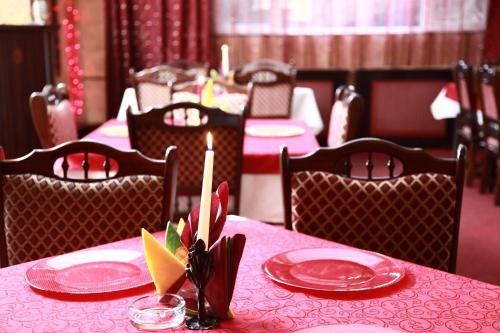 een tafel met rode borden en kaarsen erop bij Motel Davios in Târgu Jiu