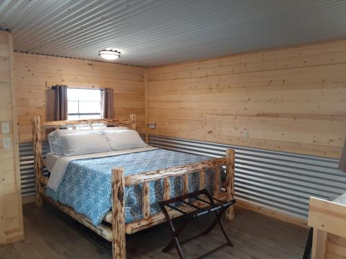 - une chambre avec un lit dans une pièce en bois dans l'établissement Glacier Acres Guest Ranch, à Columbia Falls