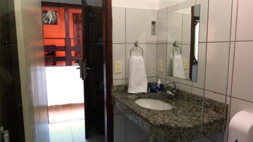 uma casa de banho com um lavatório e um espelho em Che Lagarto Hostel Itacaré em Itacaré