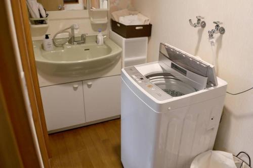 La salle de bains est pourvue d'un lave-linge et d'un lavabo. dans l'établissement Tsukuyomi Chuodori, à Kanazawa