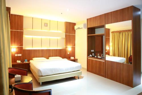 a hotel room with a bed and a desk and a room at Aviari Hotel in Sekupang