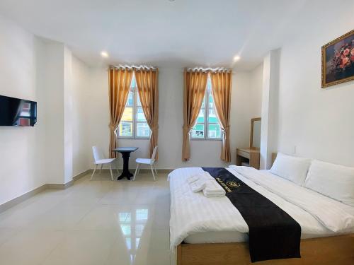 une chambre avec un grand lit et deux fenêtres dans l'établissement Dalat Joy Hotel, à Đà Lạt