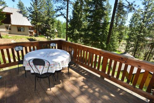 a table and chair on a wooden deck at The Park Chalet by Casago McCall - Donerightmanagement in McCall