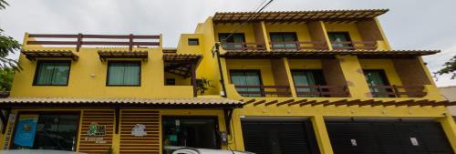 a yellow building with a balcony on top of it at Costa Dourada Pousada in Arraial do Cabo