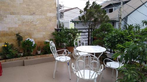 a patio with a table and chairs and plants at Mai DaLat Homestay in Da Lat