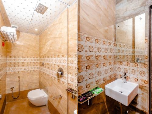 a bathroom with a sink and a toilet and a shower at Hotel Alfa Heritage in Mumbai