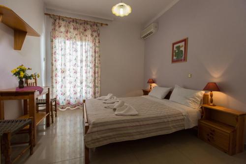 a bedroom with a large bed and a table at Filoxenia Studios 1 in Palaiochóra