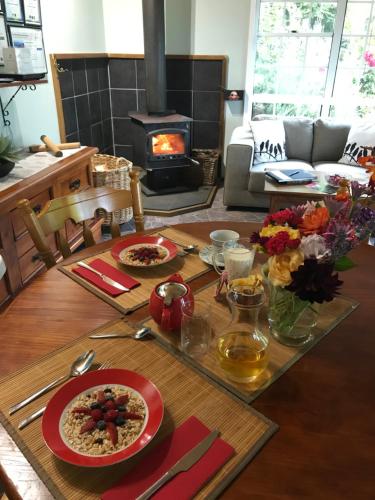 mesa de comedor con comida y chimenea en Hillside Bed and Breakfast, en Huonville