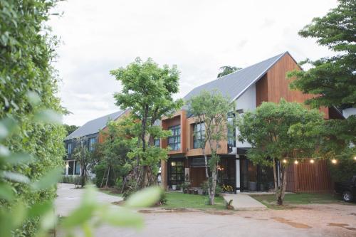 a building with trees in front of it at Karpenter Lampang in Lampang