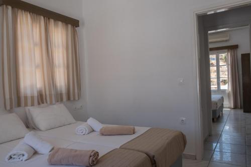 a bedroom with a large bed with towels on it at Paradise Apartments Studios in Mylopotas