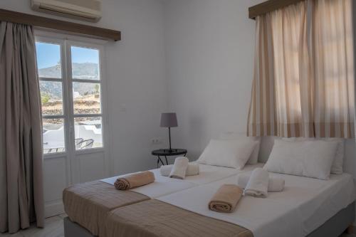 a large white bed in a room with a window at Paradise Apartments Studios in Mylopotas