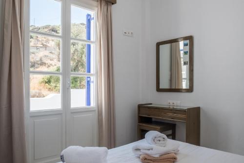 a bedroom with a window and a bed with towels at Paradise Apartments Studios in Mylopotas