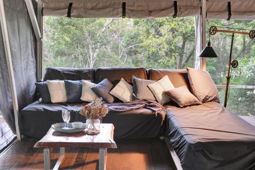 a couch in a living room with a table at Starry Nights Luxury Camping in Woombye
