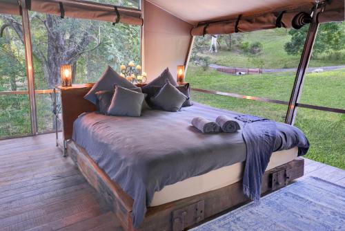 Bett in einem Zimmer mit einem großen Fenster in der Unterkunft Starry Nights Luxury Camping in Woombye