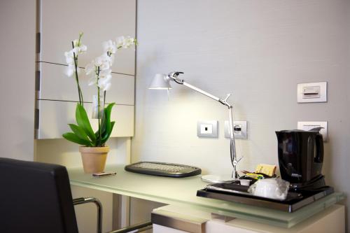 a desk with a coffee maker and a lamp on it at Hotel Mercure Milano Solari in Milan