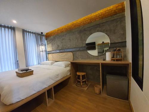 ein Schlafzimmer mit einem großen Bett und einem Spiegel in der Unterkunft The Singha Hotel - Korat in Nakhon Ratchasima