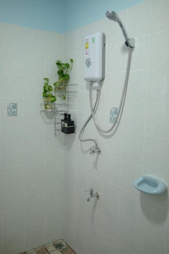 a shower in a white tiled bathroom with a sink at Little B house in Ban Tao Than