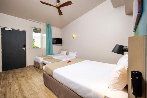 a hotel room with two beds and a ceiling fan at Gondwana City Green in Noumea