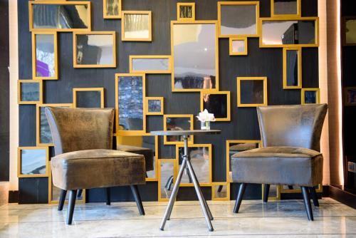 two chairs and a table in front of a wall with pictures at Studio Ekamai in Bangkok