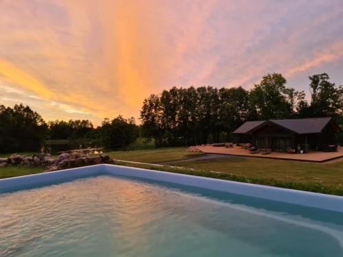 Blick auf den Pool bei Sonnenuntergang mit einem Zelt in der Unterkunft Pennu Villa in Vahtra