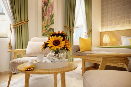 a living room with a vase of sunflowers on a table at The Pearl Hotel in Hanoi