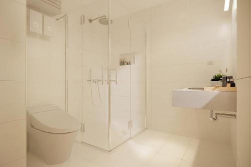 a bathroom with a shower and a toilet and a sink at The Pearl Hotel in Hanoi