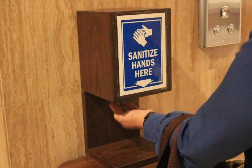 a person is reaching for a sign on a wall at Hotel Chanti Managed by TENTREM Hotel Management Indonesia in Semarang