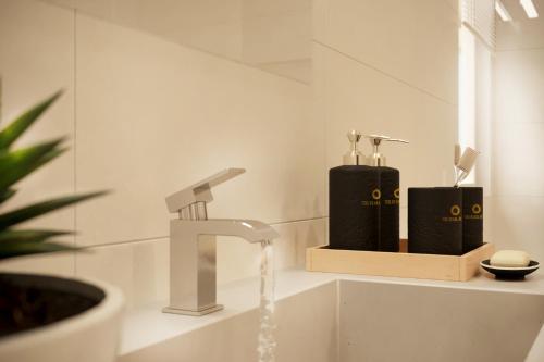 La salle de bains est pourvue d'un lavabo avec un robinet. dans l'établissement The Pearl Hotel, à Hanoï