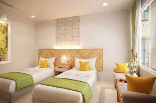 een hotelkamer met 2 bedden en een bank bij The Pearl Hotel in Hanoi