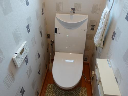 Łazienka z białą toaletą i umywalką w obiekcie machiyado Kuwanajuku Honmachi 10 w mieście Kuwana