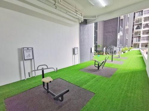 a room with green grass and benches in a building at D'Pristine Theme Suite by Nest Home at LEGOLAND in Nusajaya