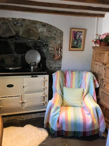 a chair with a pillow sitting next to a dresser at Holiday Home Church Street in Beaumaris