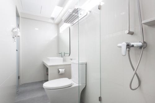 a bathroom with a shower and a toilet and a sink at Samran Place Hotel in Bangkok