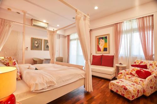 a bedroom with a canopy bed and a couch at Memory Garden in Luodong