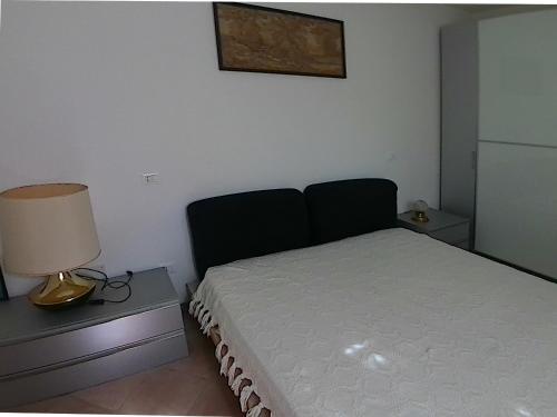 a bedroom with a bed and a lamp on a table at Little Star Pioppa in Riondi