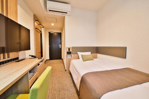 ein Hotelzimmer mit zwei Betten und einem Flachbildfernseher in der Unterkunft Rembrandt Style Gotemba Komakado in Gotemba