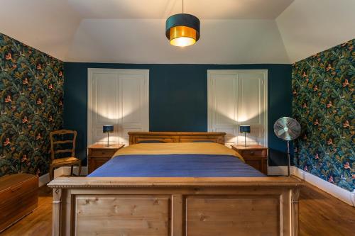- une chambre avec un lit aux murs bleus et un ventilateur dans l'établissement Domaine La Rose, à Caylus