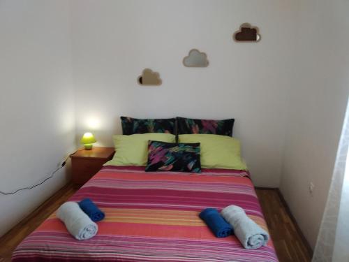 a bed in a room with two pillows on it at Apartmani Maja in Pag