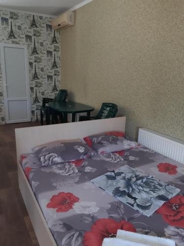 a bedroom with a bed with flowers on it at Отель Маленький Рай in Zatoka